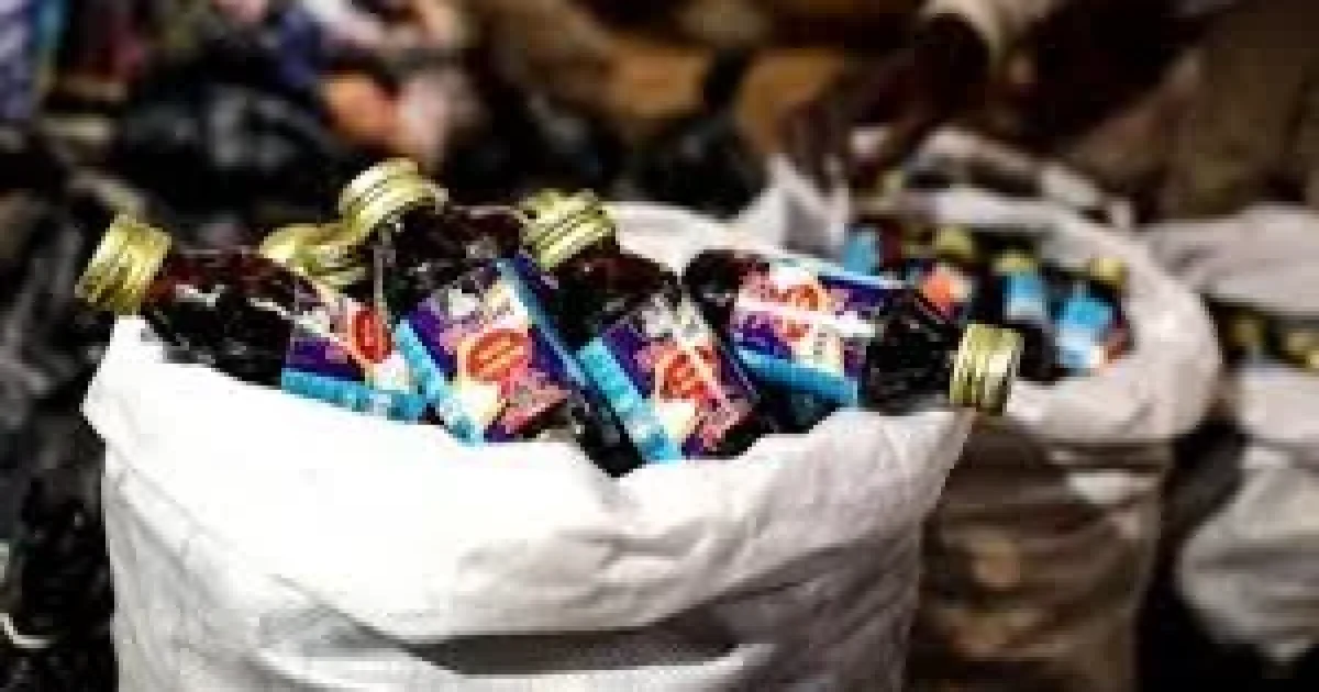 NDLEA operatives display 1,499 bottles of codeine-based cough syrup seized from a suspect in Kano during an anti-drug operation.